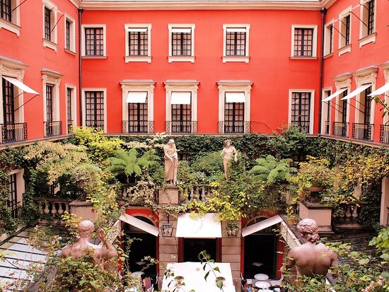 Dark panelled hotel courtyard with columns and heavy draped fabric