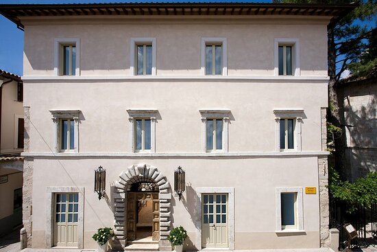 Stone palazzo elevation with an arched doorway on a narrow town street