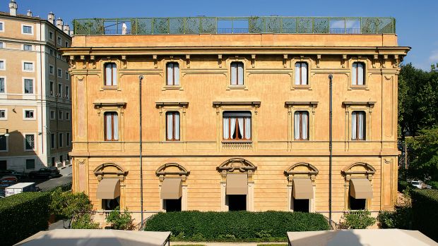 Stone townhouse front with tall shuttered windows on a quiet Rome street