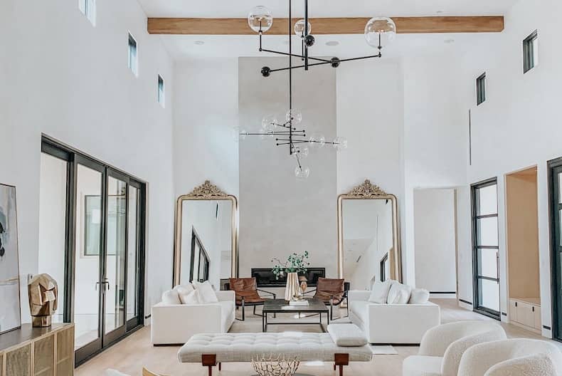 Hotel sitting room with tall windows, seating and framed work on the walls