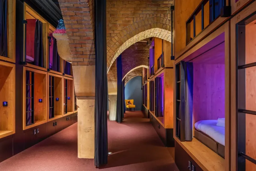 Church interior with arched windows and timber sleeping modules built below