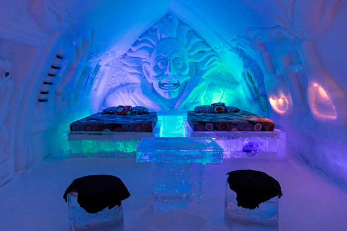 Vaulted corridor of packed snow with carved openings along both walls