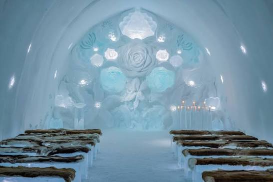 Hall with walls of clear blocks and carved openings lit from within